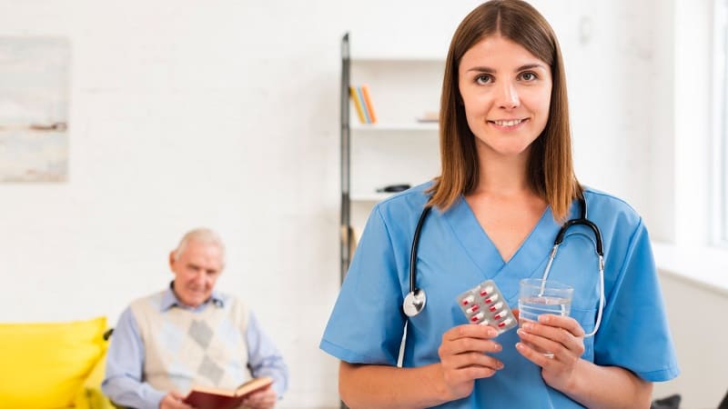 پرستار انگلیسی با پاسپورت و بیمار در پس‌زمینه