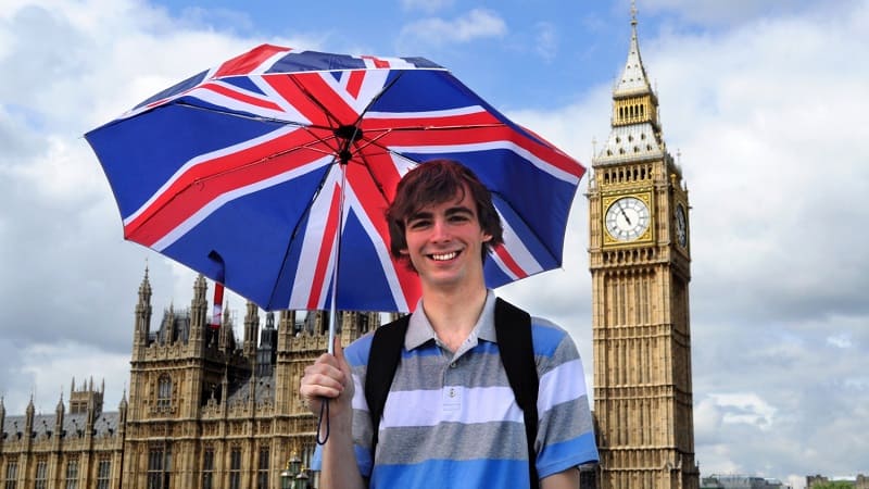 دانشجو با چتر پرچم بریتانیا کنار بیگ بن